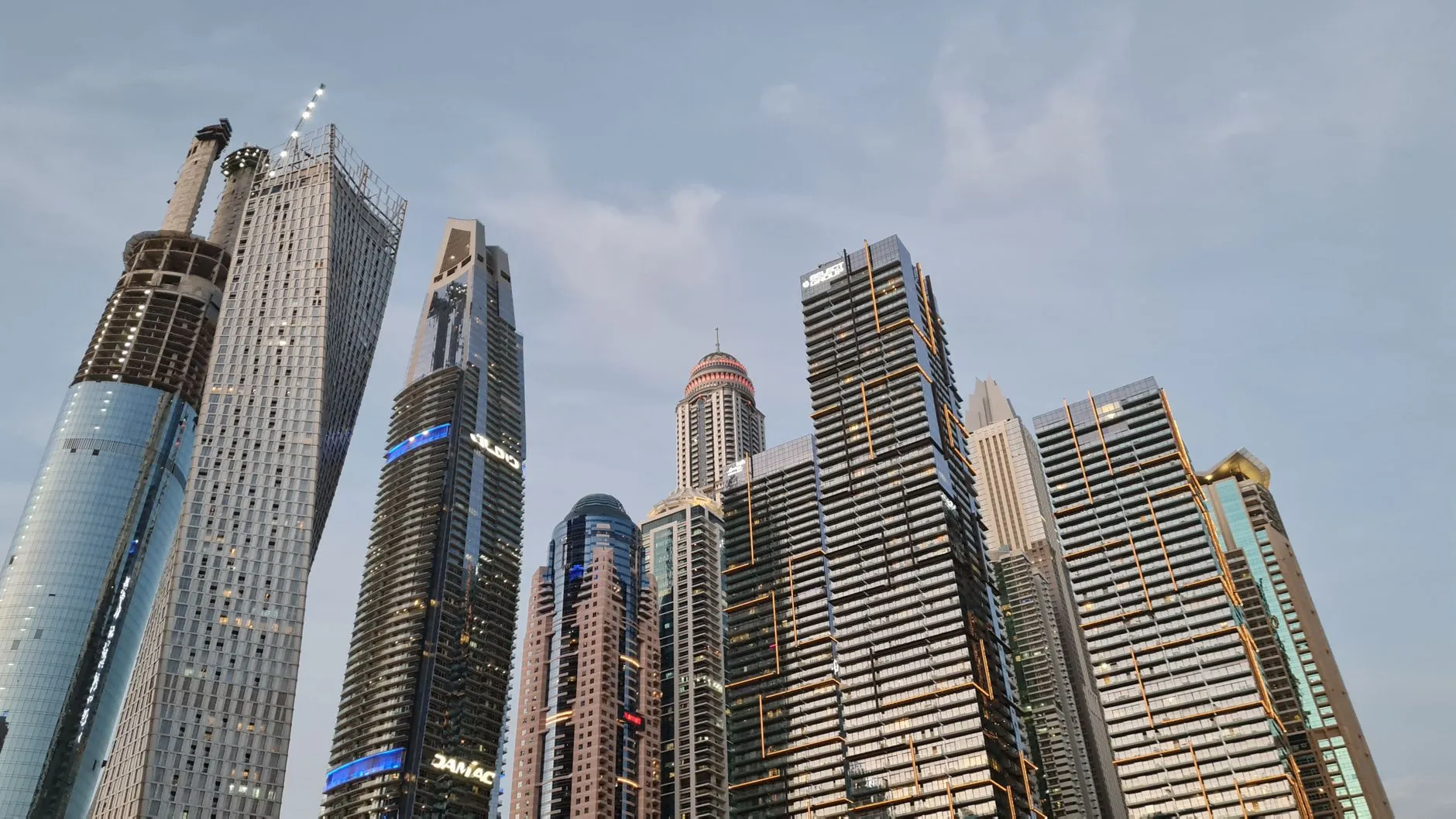 An aerial photo showing a large Dubai real estate development with both finished and under-construction buildings.