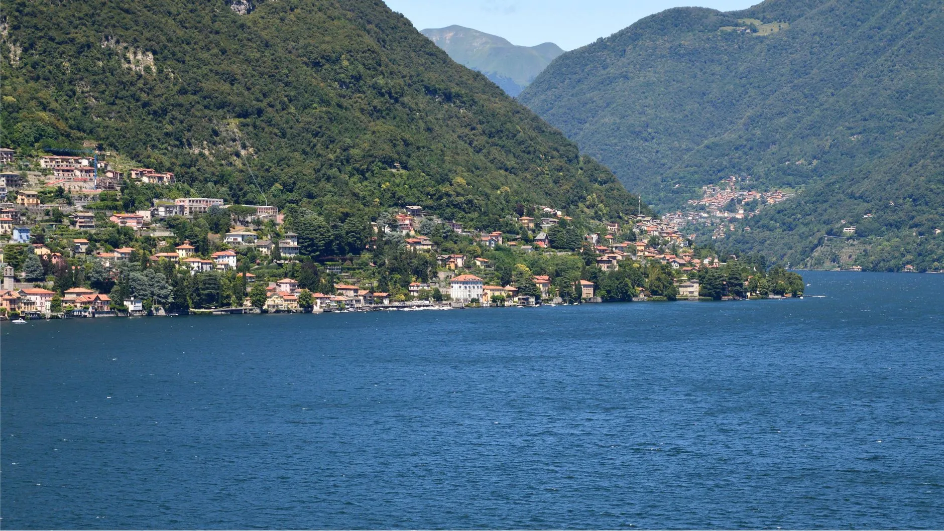 Panoramic view of Lake Como with traditional Italian villas along the shore.